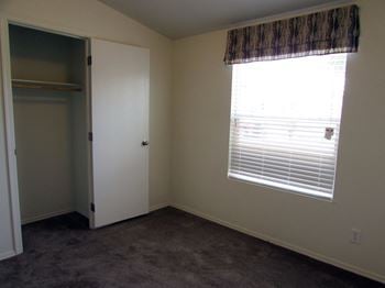 An empty room with a large window and a closet